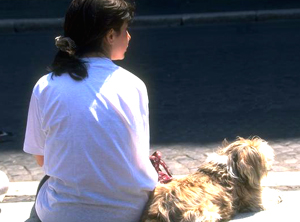 mujer adolescente sentada junto a un perro